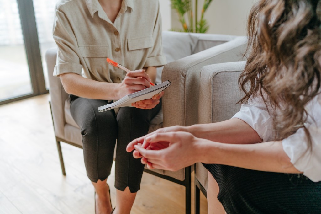 Close-up of young woman talking about her mental health problems to the doctor during counseling. Mental health concept.