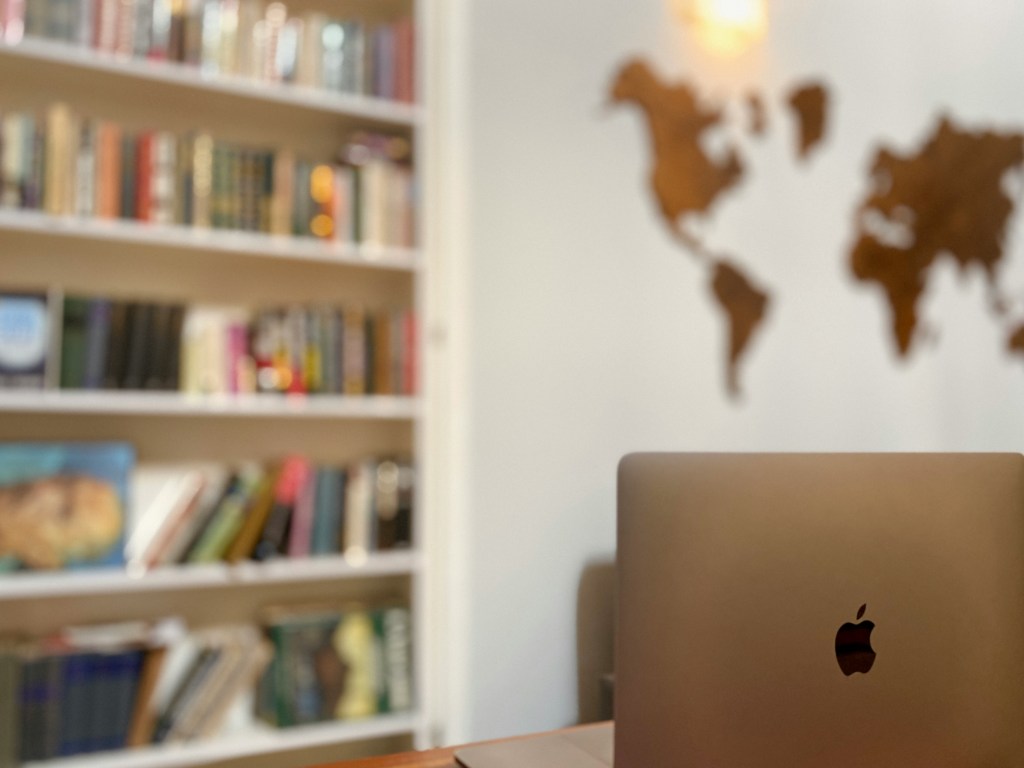 Blurred home office background with apple laptop at forefront.